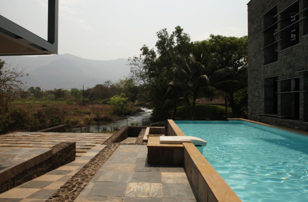 At the entrance of the house is a swimming pool that overlooks the river and the surrounding landscape.