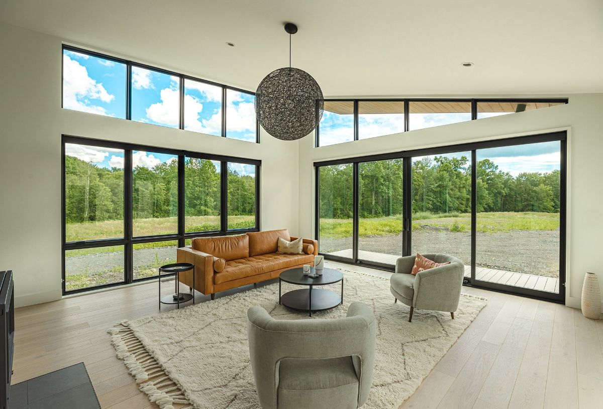 The minimalist living room has a glass door that leads to the patio.