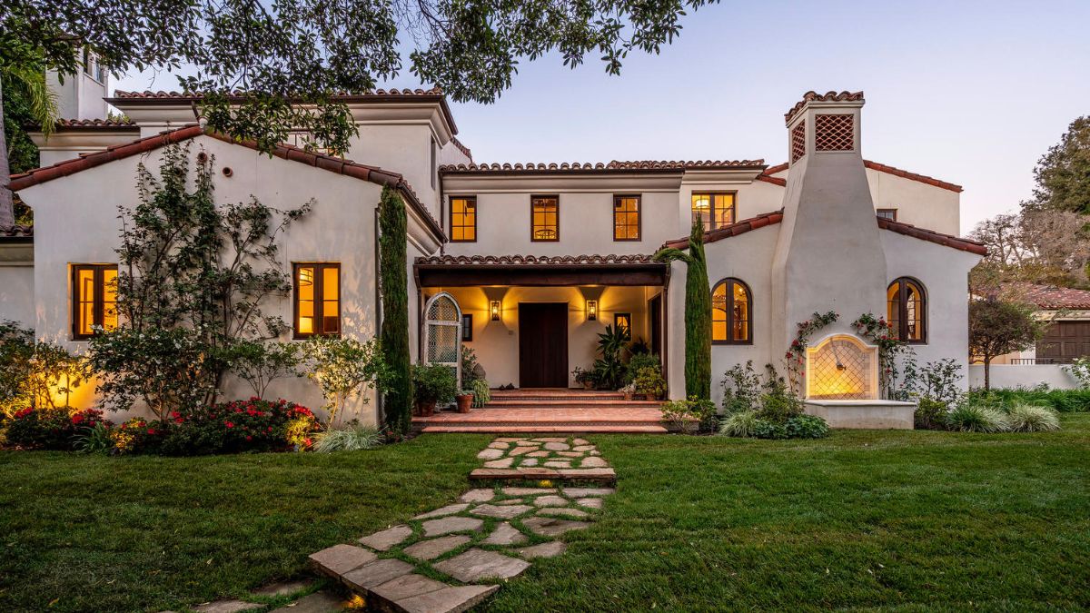 A front door pathway with a set of rocky steps and lush grass beside.