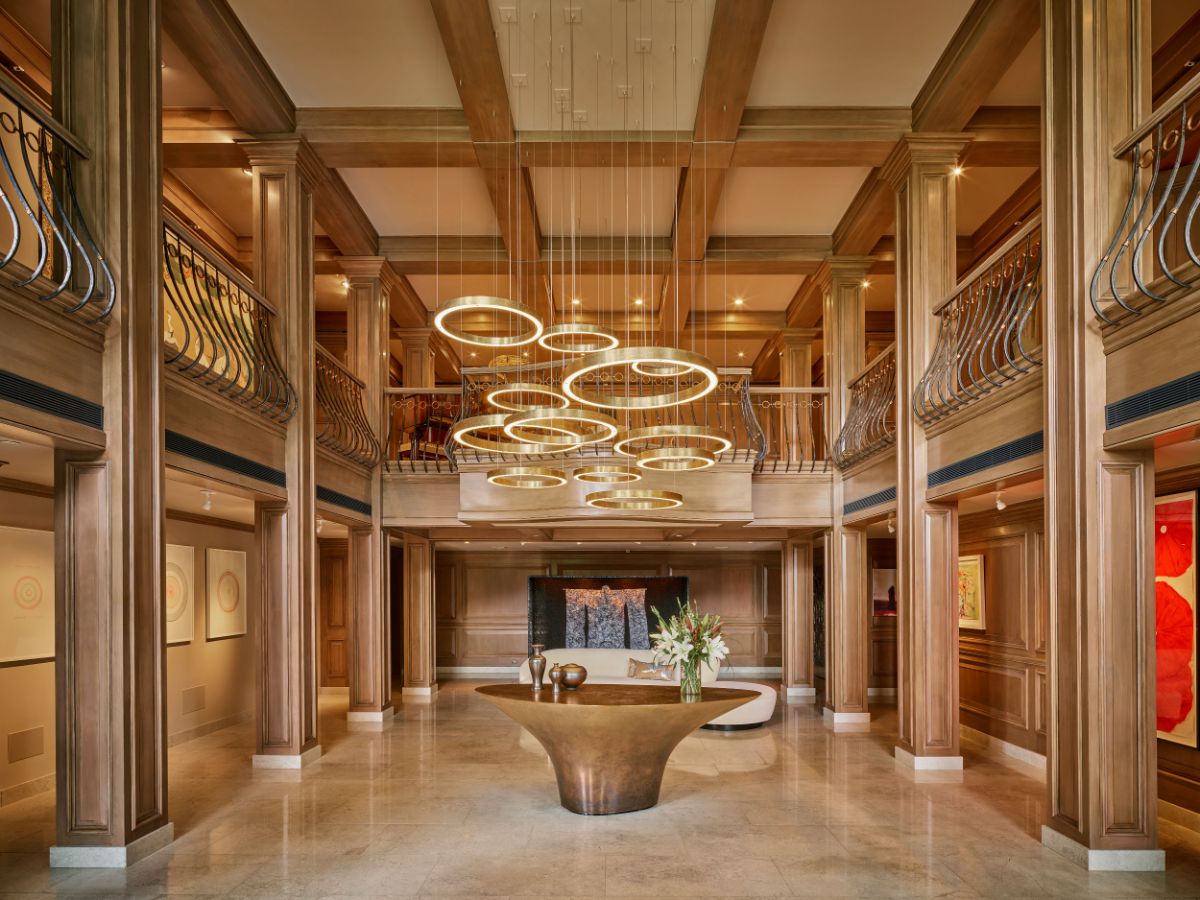 The grand, two-story foyer features gold accents and a magnificent chandelier is chic and striking. Image courtesy of Toptenrealestatedeals.com