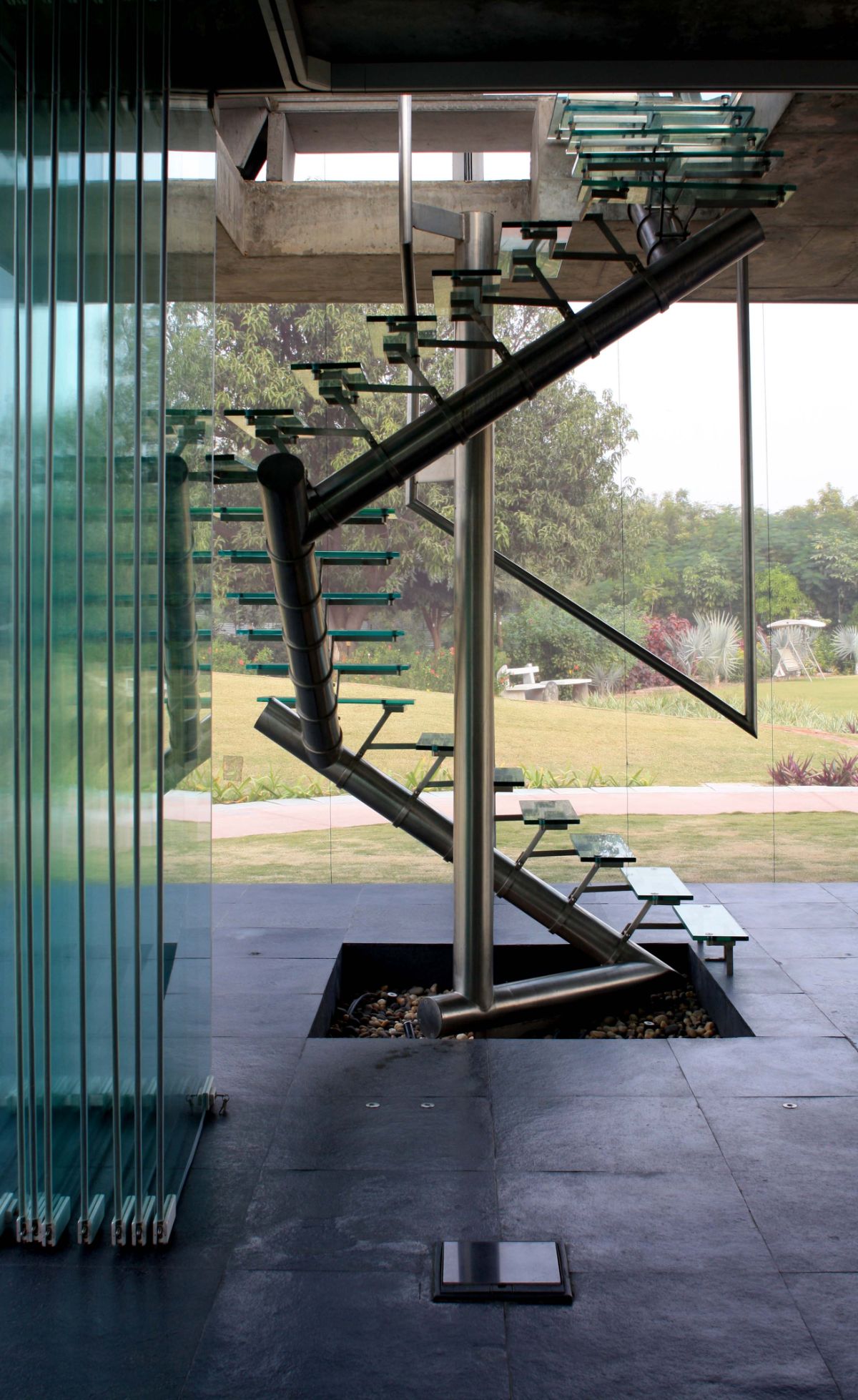 Floating glass stairs wrap around the rainwater down takepipe that transfers water from the roof to the 1 million liter rainwater storage tank underground.