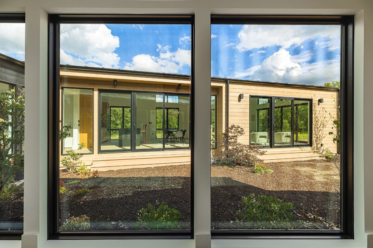 In the wall way, the kitchen, the living room, and the dining area can be seen through the glass windows.