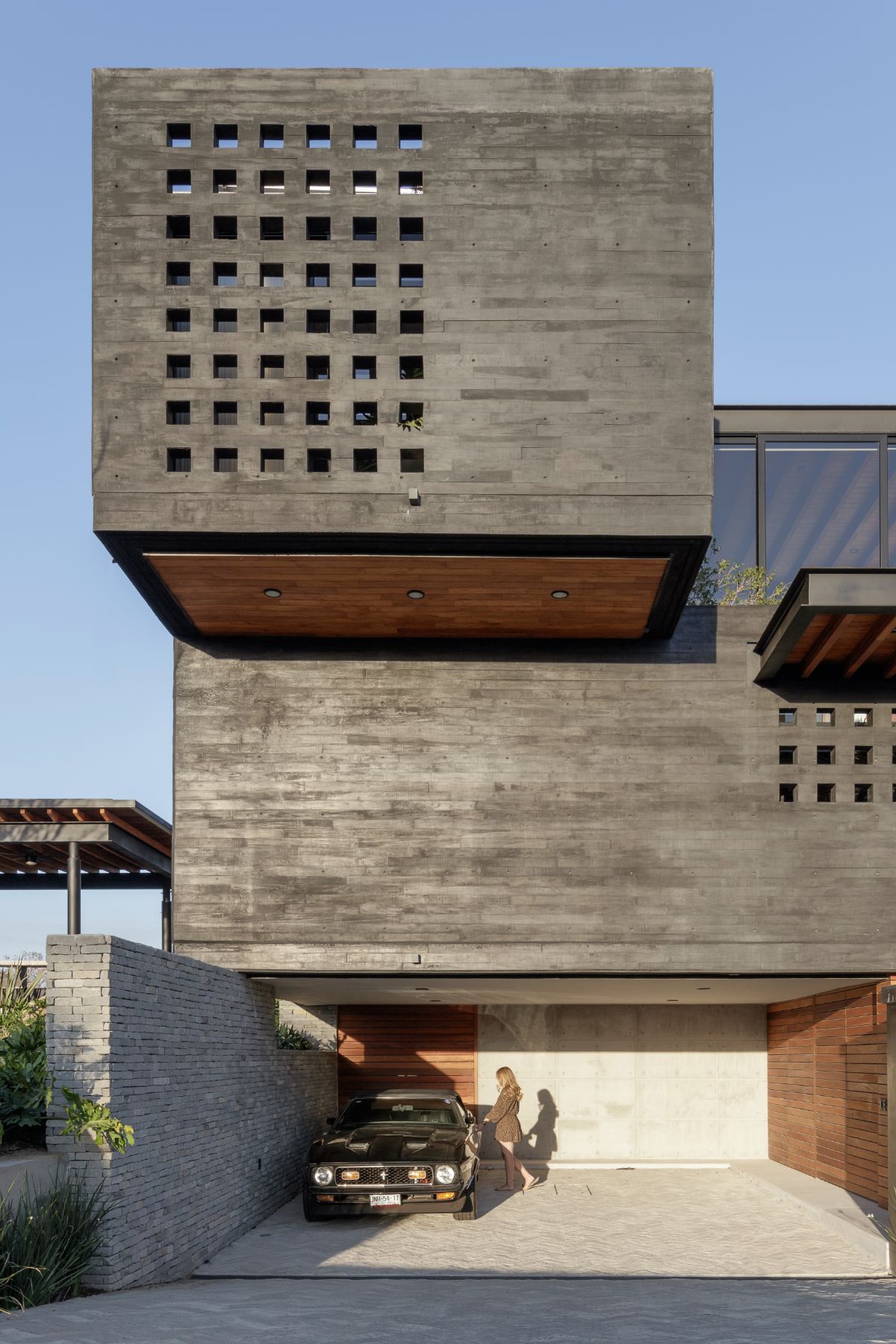 A garage with a classic car and above is a cantilever of the bedroom.