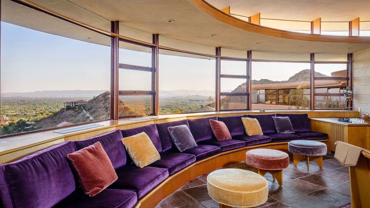 The interior of the house is enhanced by velvety violet seating with small square-shaped pillows in a variety of colors and small chairs.