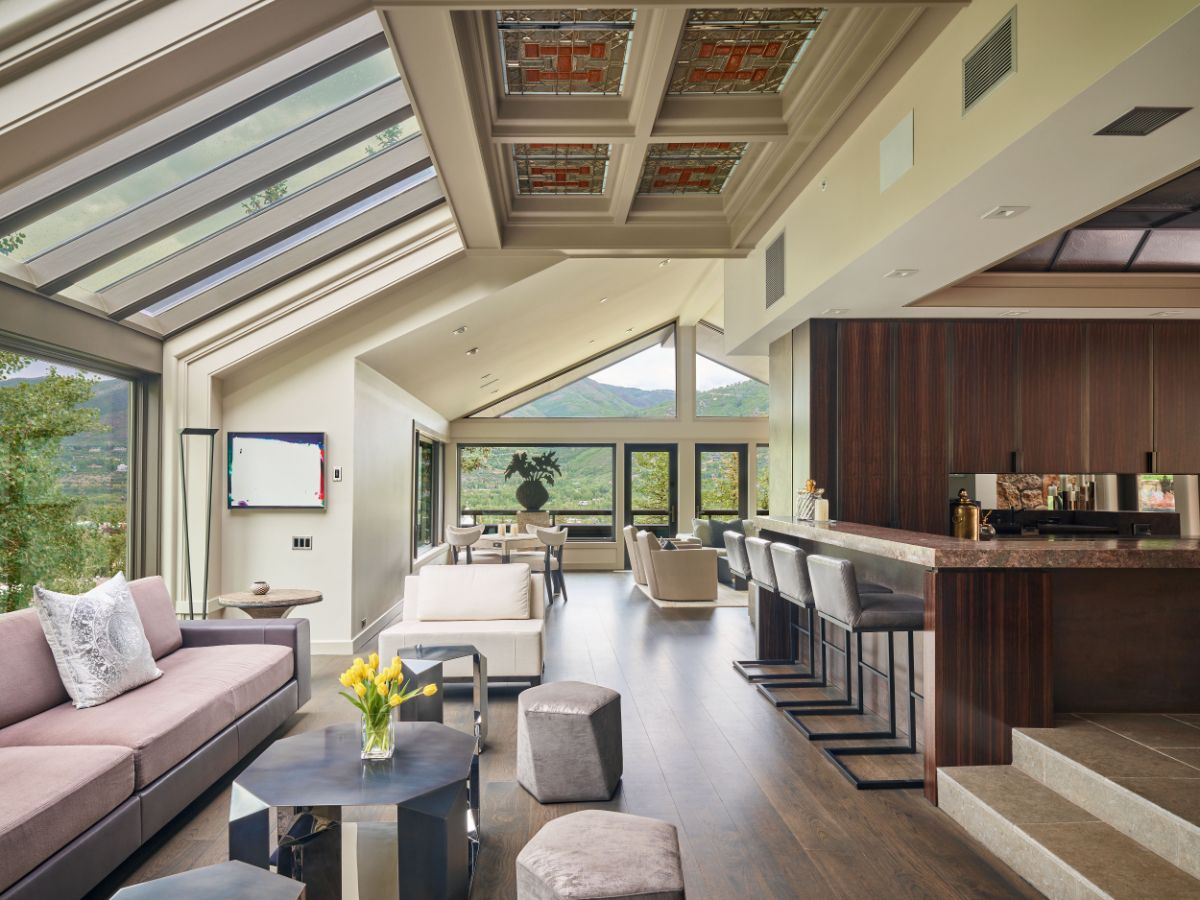 A spacious floor-plan, big windows, and multiple skylights, including a striking stained glass ceiling in the great room, provide open, light-filled interior spaces. Image courtesy of Toptenrealestatedeals.com