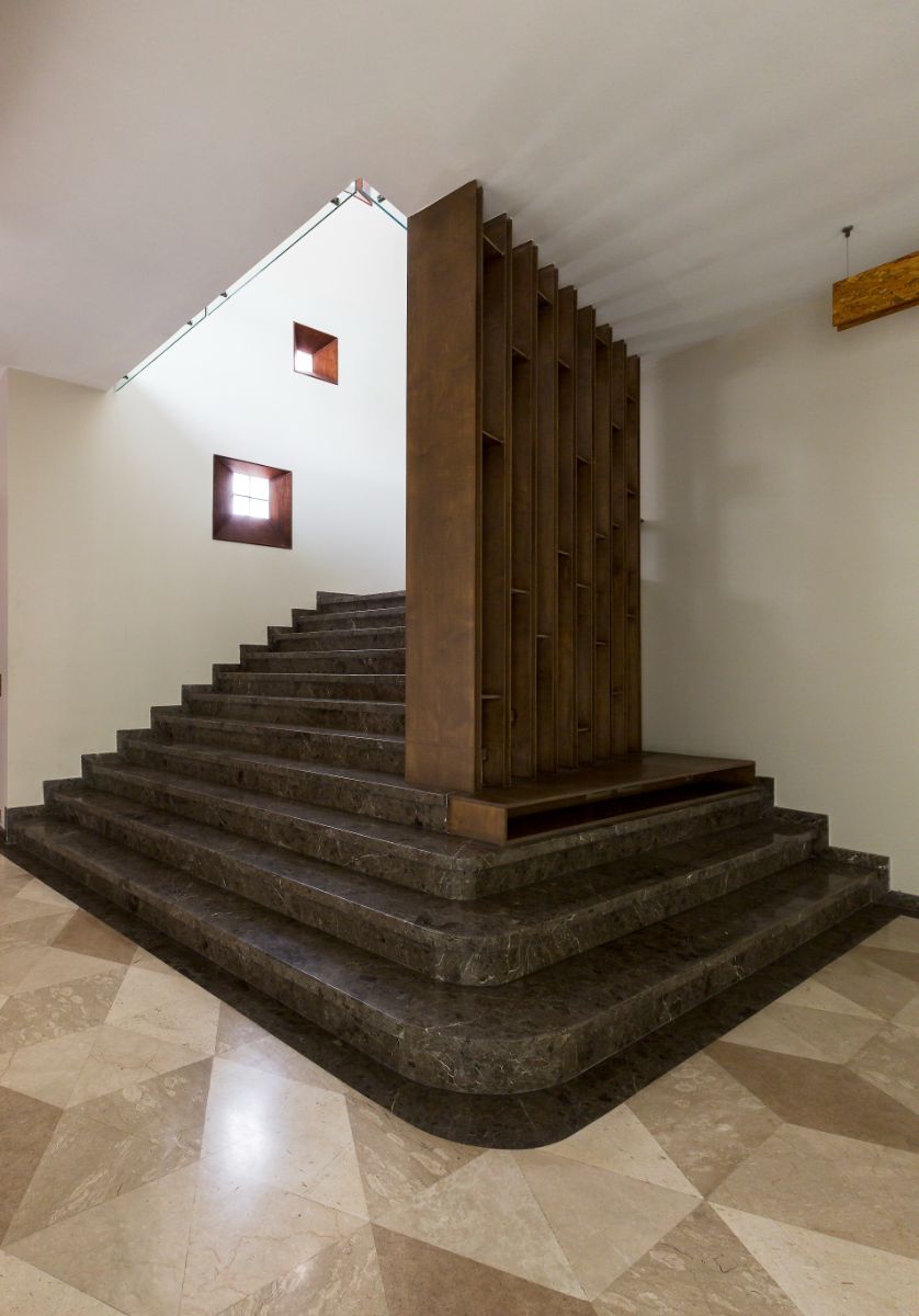 The stair was designed in a unique way, with open wooden shelving and a pin hole that illuminated the area.