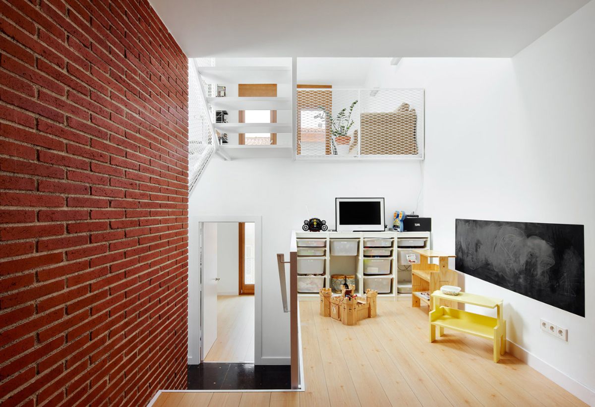 The second floor of the house is intended for children, and the presence of a brick wall gives the room an aesthetic feeling.