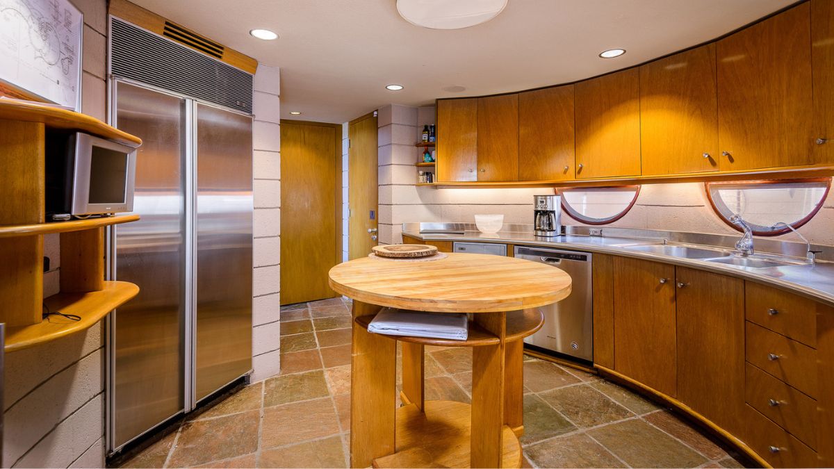 The kitchen included wooden furnishings from the storage to the island counter table, and the appliances were steel.