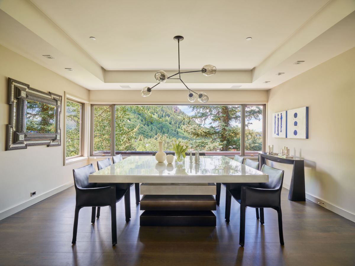 A formal dining room with large windows that provide views of the majestic Aspen Mountain Gondola. Image courtesy of Toptenrealestatedeals.com