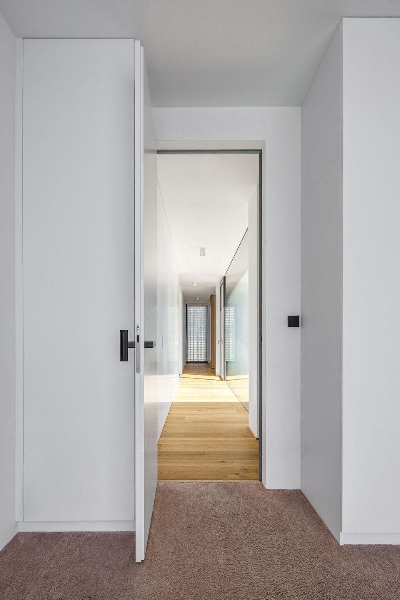 A hallway leading to a private wing with bedrooms.