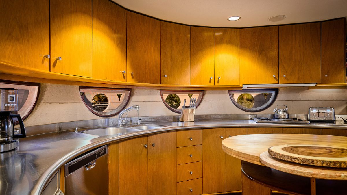 From the inside, a specific wooden kitchen in a circle shape with little windows overlooking the mountain.