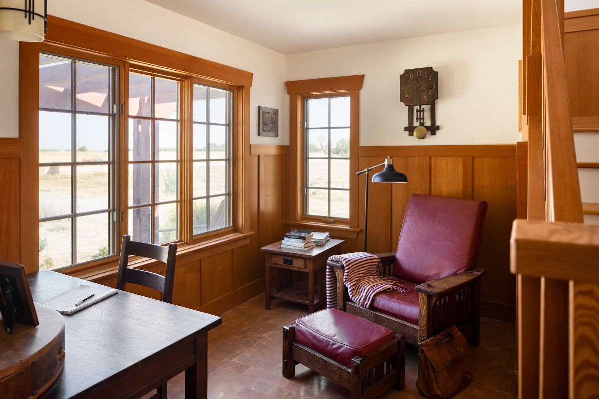 The study features an antique seat and wall clock giving the room a classic feel.