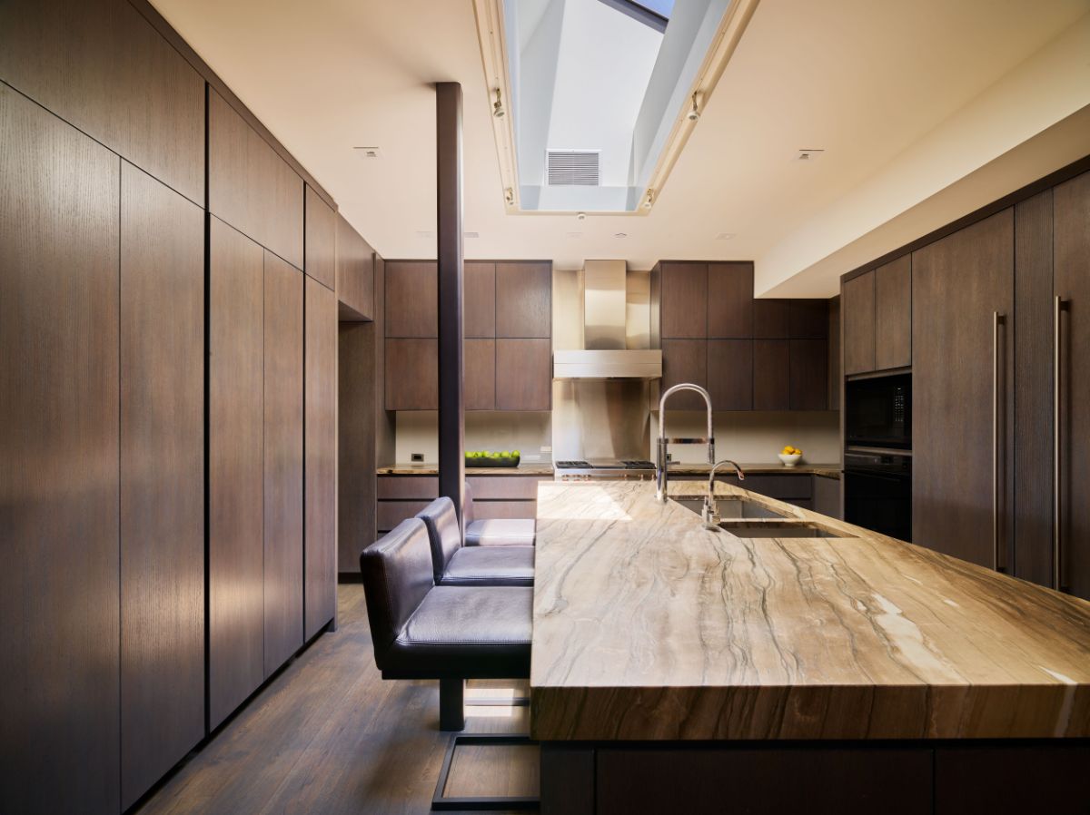 The stylish kitchen that features creamy walls and dark hardwoods provide sleek, contemporary aesthetic looks. Image courtesy of Toptenrealestatedeals.com