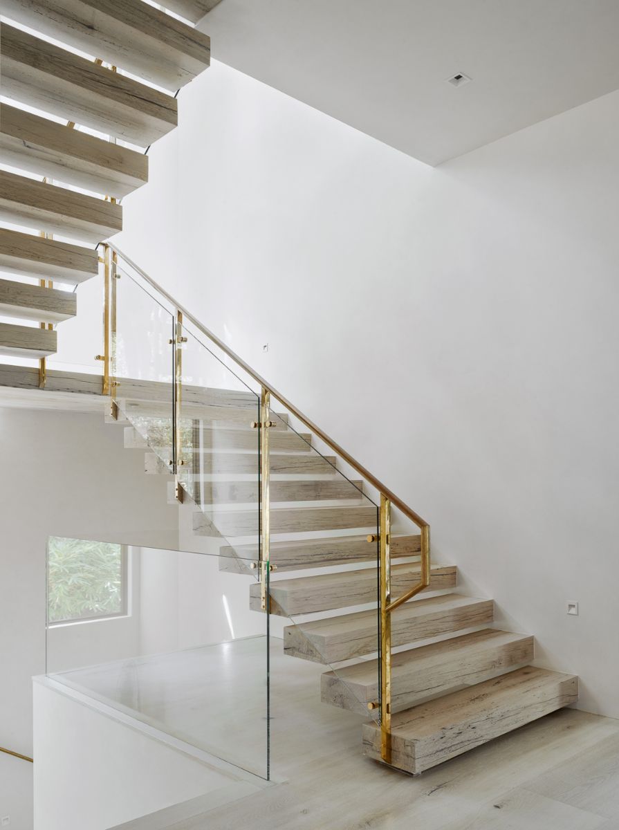 A U-shaped stair with glass and steel railings and hard wood steeps.