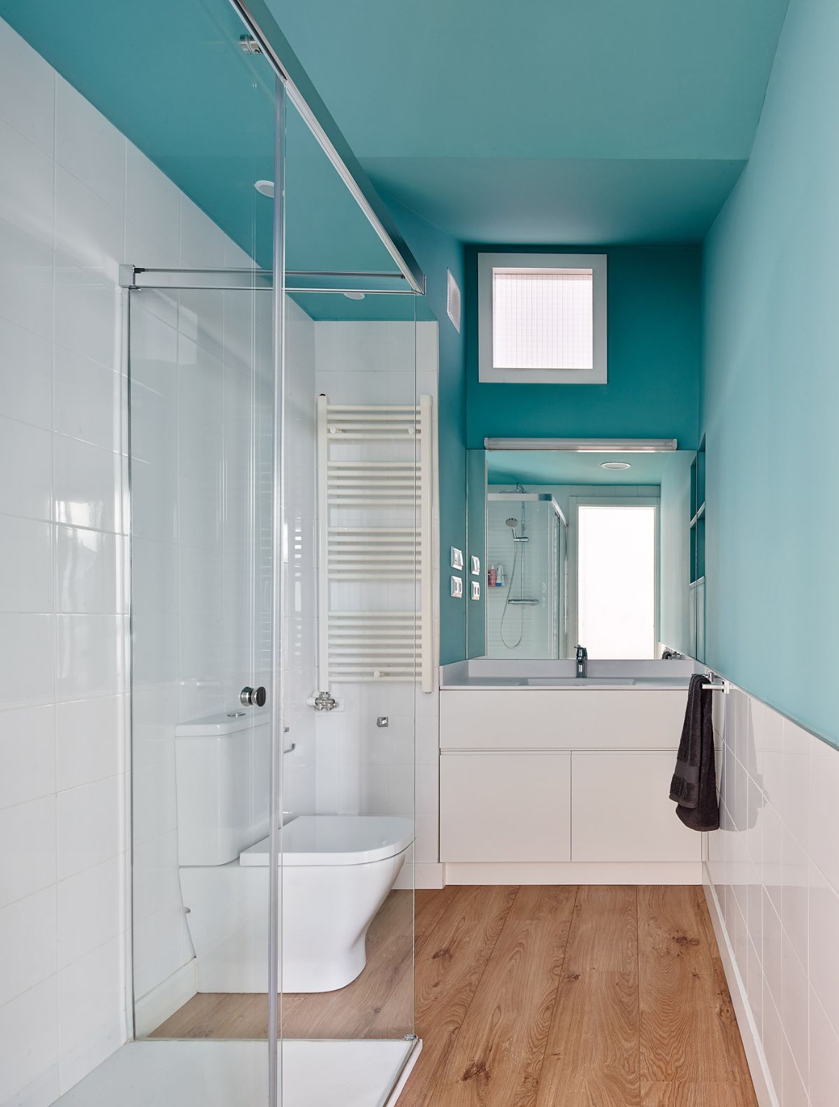 The bathroom has a shower enclosure that prevents water from flooding into the outside area.