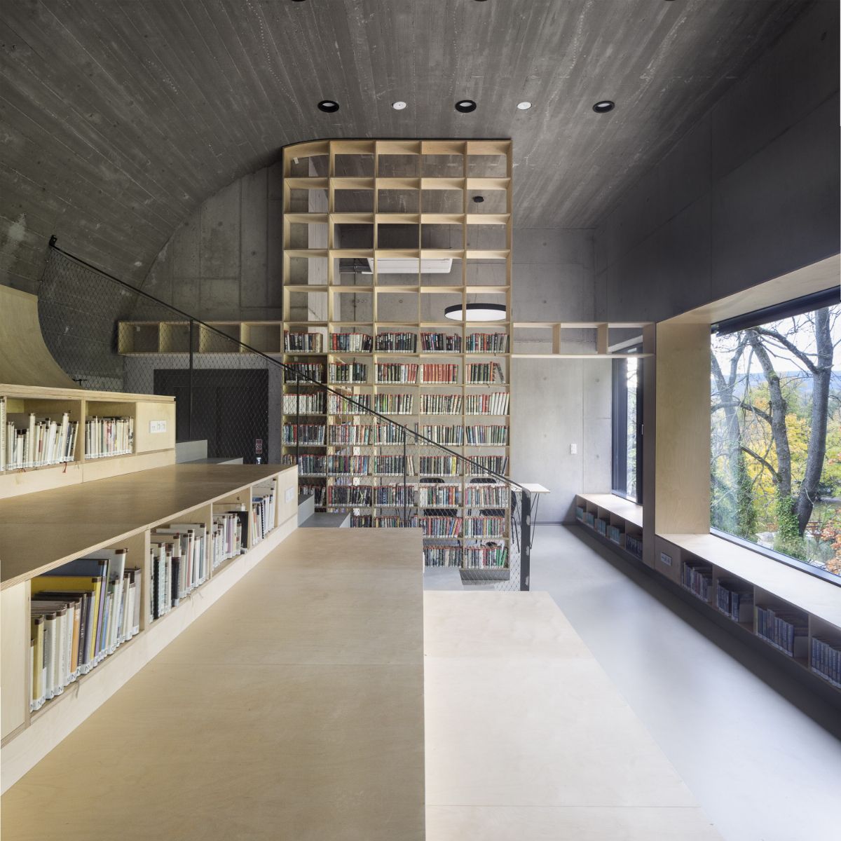 A first-floor gallery and a reading room under an arched roof.