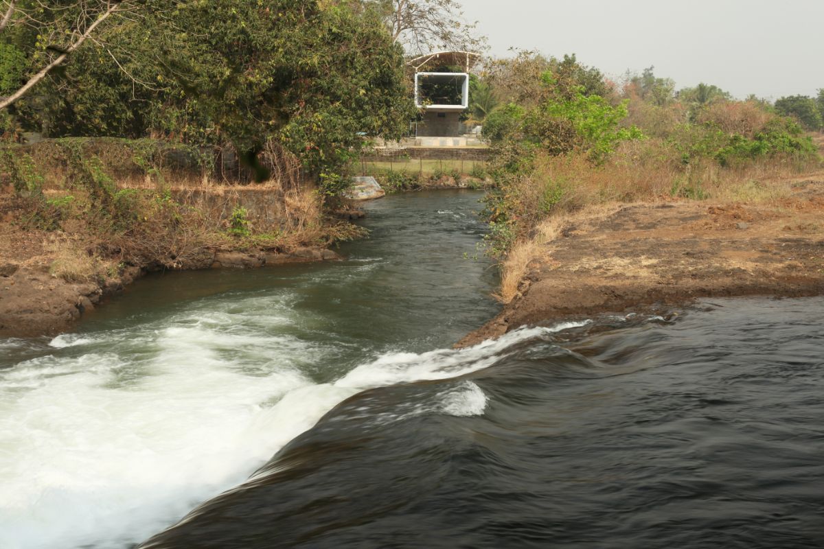 The house is surrounded by beautiful scenery such as a waterfall and landscapes.