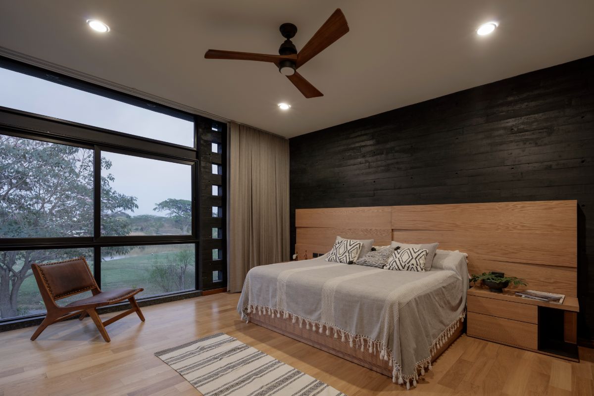 The wooden flooring and the headboard on the bed create a rustic effect on the master suite giving off a cozy atmosphere.