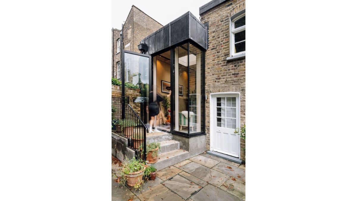 The townhouse's transparent glass main door goes with the classic brick wall stones.