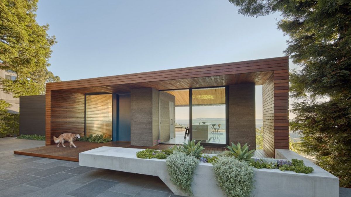 A photograph showcasing the exterior design of the SkyLine House, taken during the daytime from the garden area.