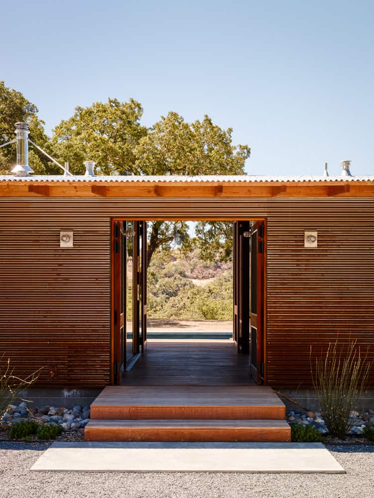 The home is clad in corten metal walls and is topped by a galvanized roof.