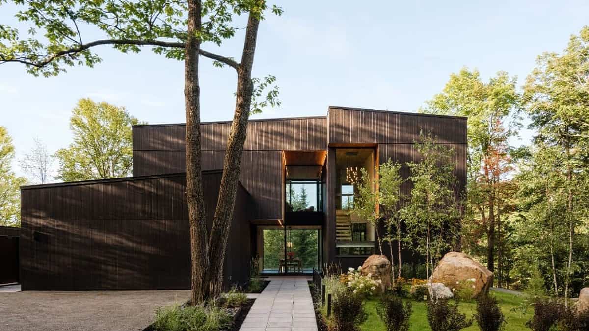 Home facade with sleek and clean lines, dark siding, and large windows.