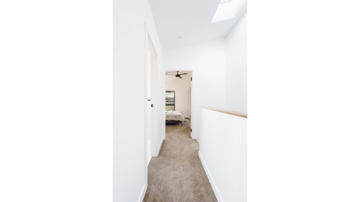 The white walls in the hallway leading to the bedroom are intended to create a light mood in the house.