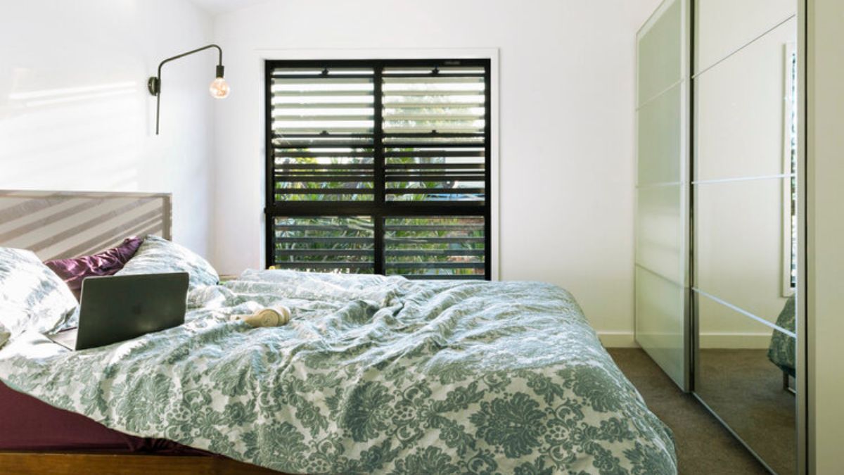 With its patterned comforter and a large mirror over the bed, the bedroom creates a unique vibe.