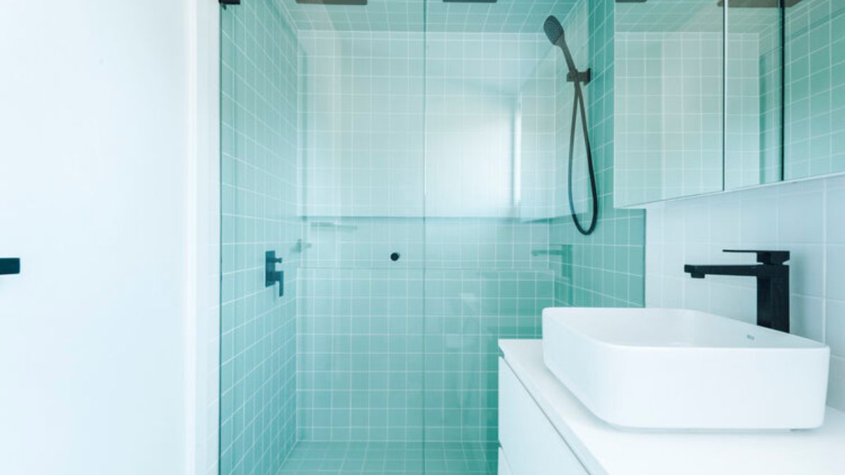 Simple bathroom design with a glass sliding door separating the sink area from the shower area.