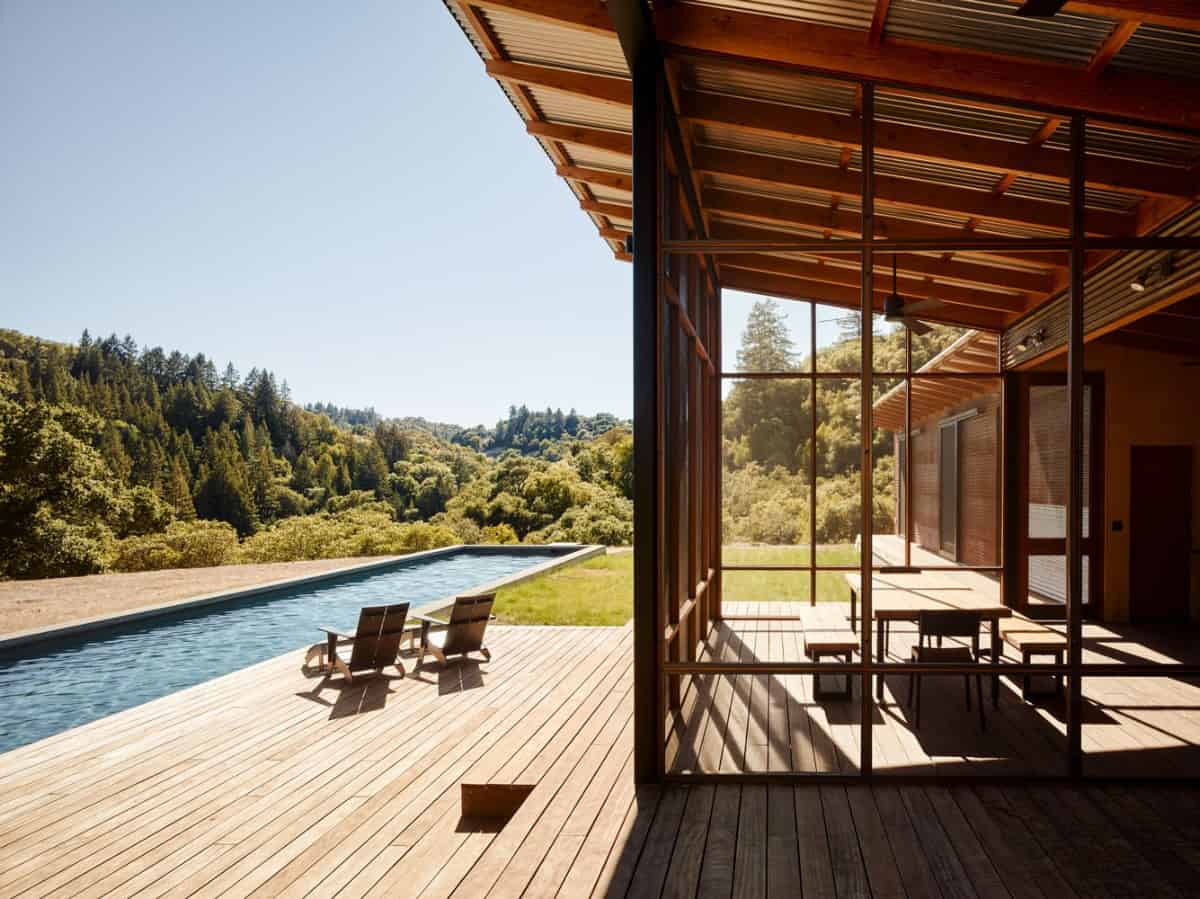 The pool deck features a lap pool and a wood deck mirrored in the dining area.