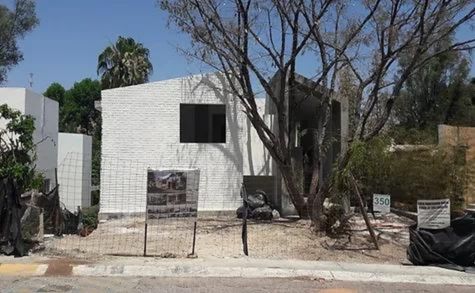 This photograph depicts the construction and painting stage of the house.