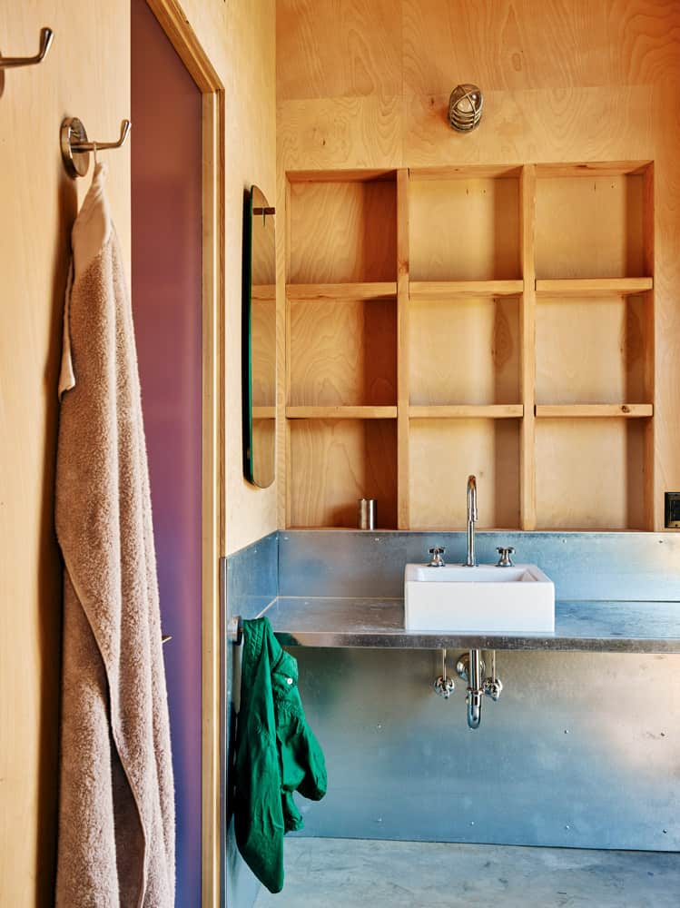 This bathroom offers a vessel sink and built-in shelves made from wood.