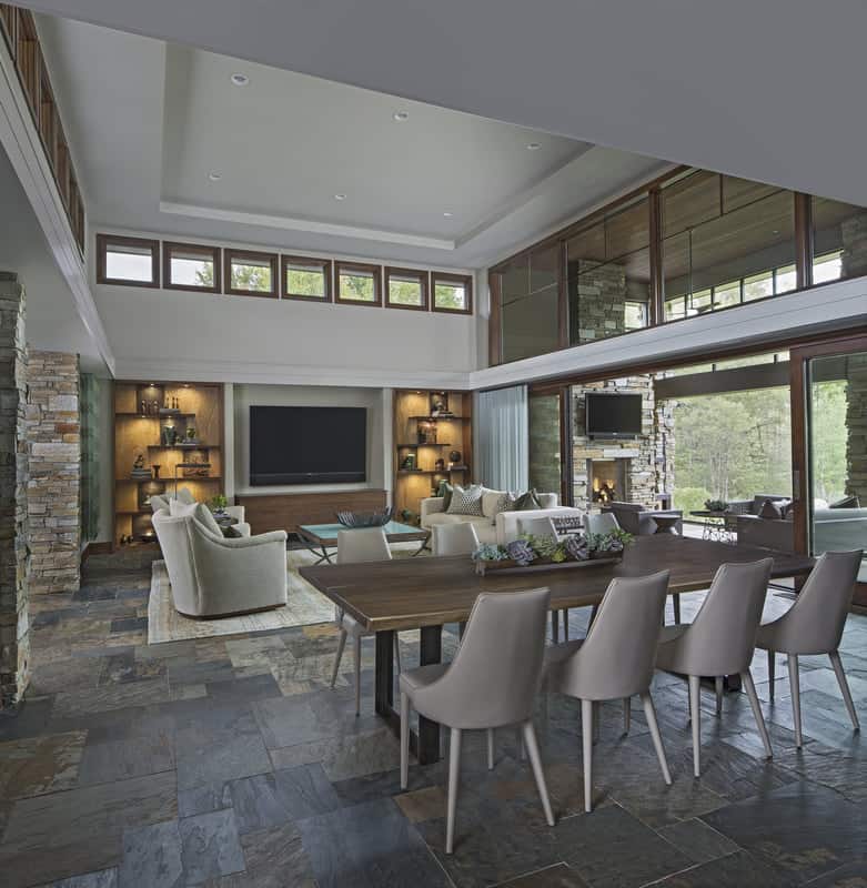 An open layout view of the living room and dining area brightened by clerestories and oversized sliding glass doors.