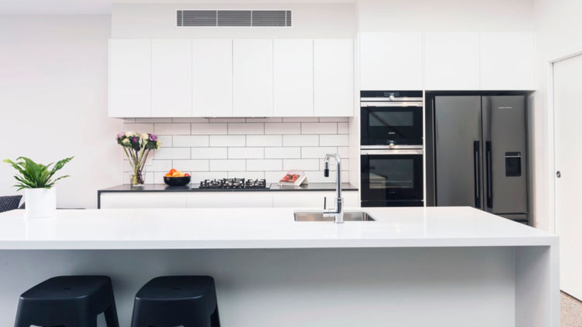 The clear angle of the white-themed kitchen features the kitchen island.