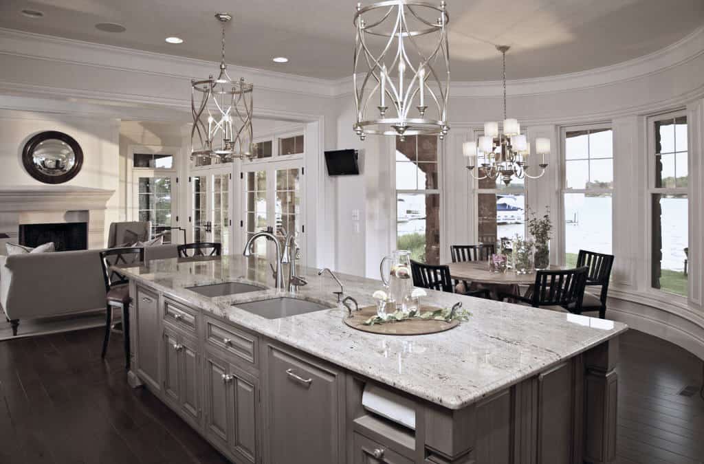 The dining area sits across the kitchen and against the bow window. It has a round dining set well-lit by a chrome chandelier.