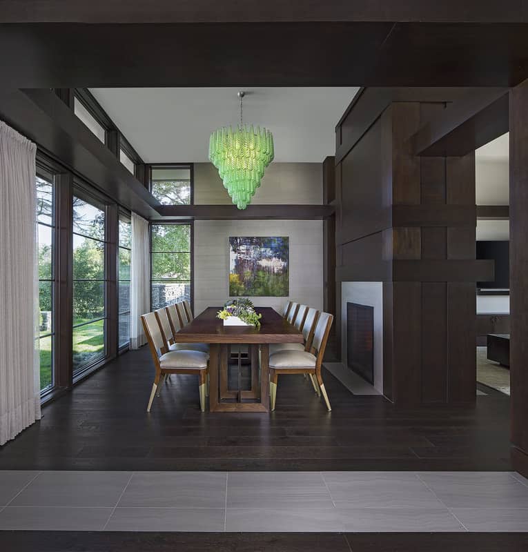 A green cascading chandelier adds a pop of color to the bright dining room.