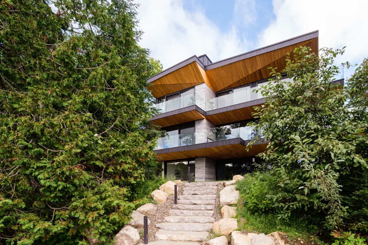 This part of the house showcases two levels of balconies bordered by glass railings.