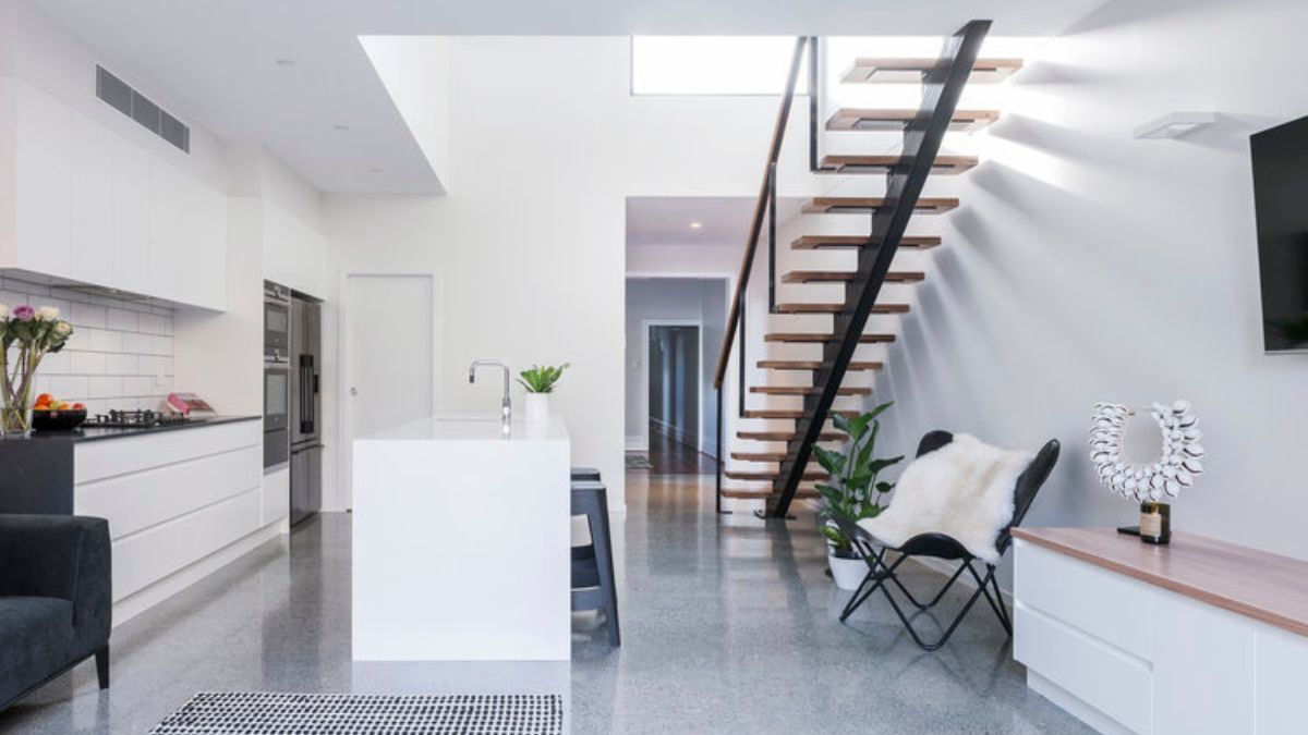 Another view shows the staircase and kitchen.