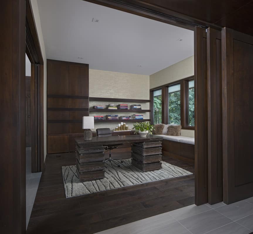 The study features a stylish wood desk sitting on a trunk patterned rug.