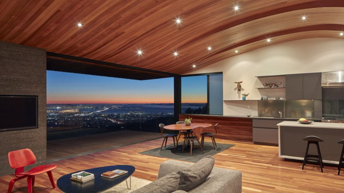 This photograph captures the nighttime cityscape of Oakland as seen from the deck in the interior shot.