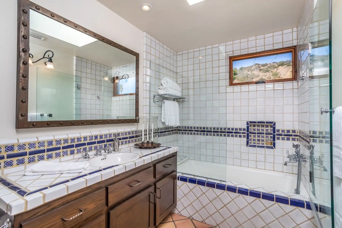 The bedroom bath features a built-in bathtub enclosed by a glass wall.