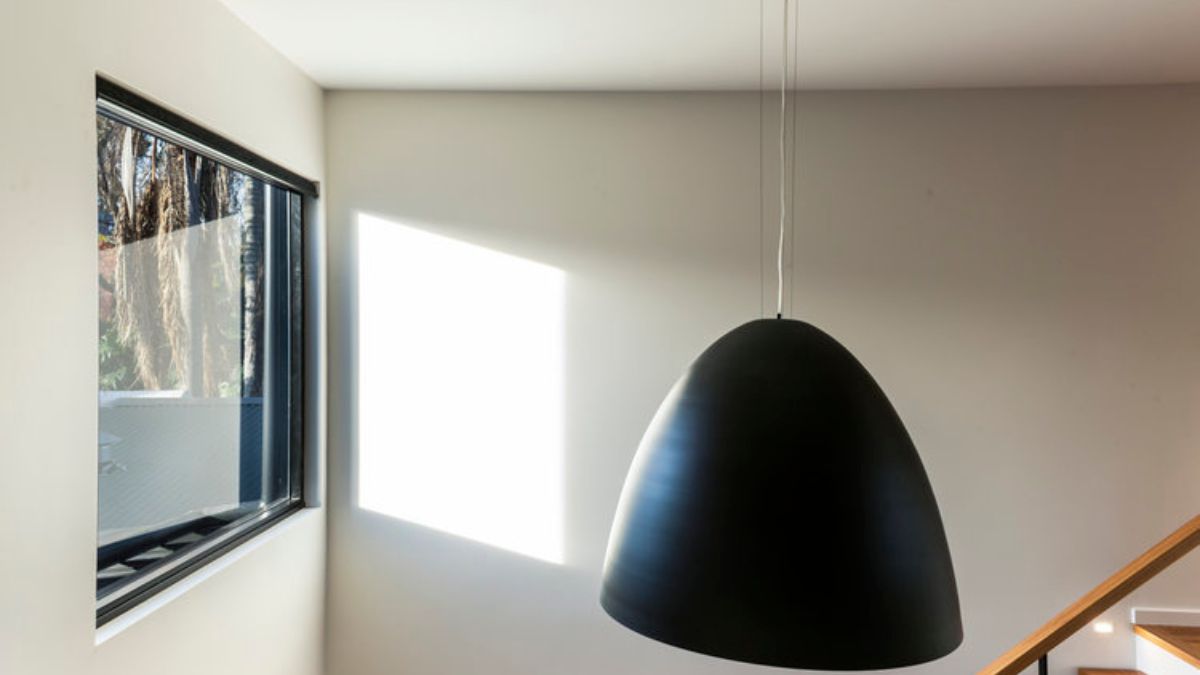 A hanging lamp that receives direct sunlight from the skylight and window.