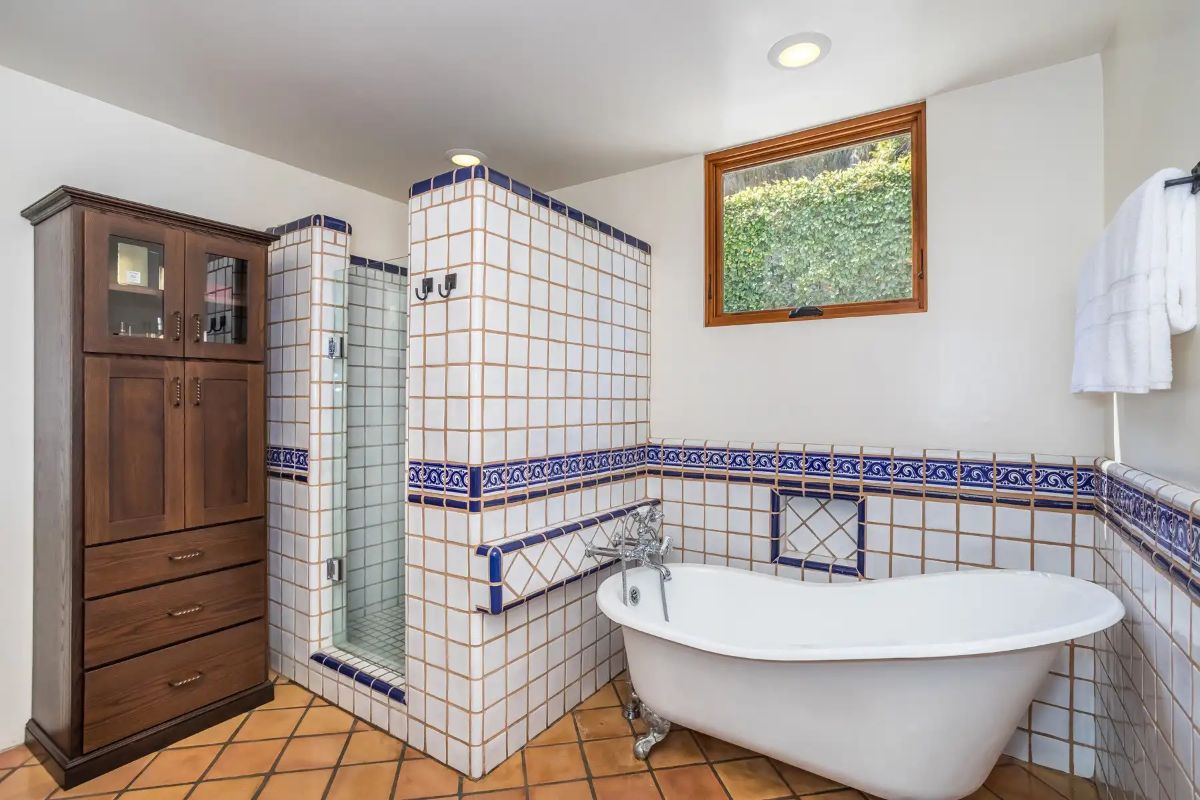 The bathroom features a free-standing bathtub and a shower cubicle.