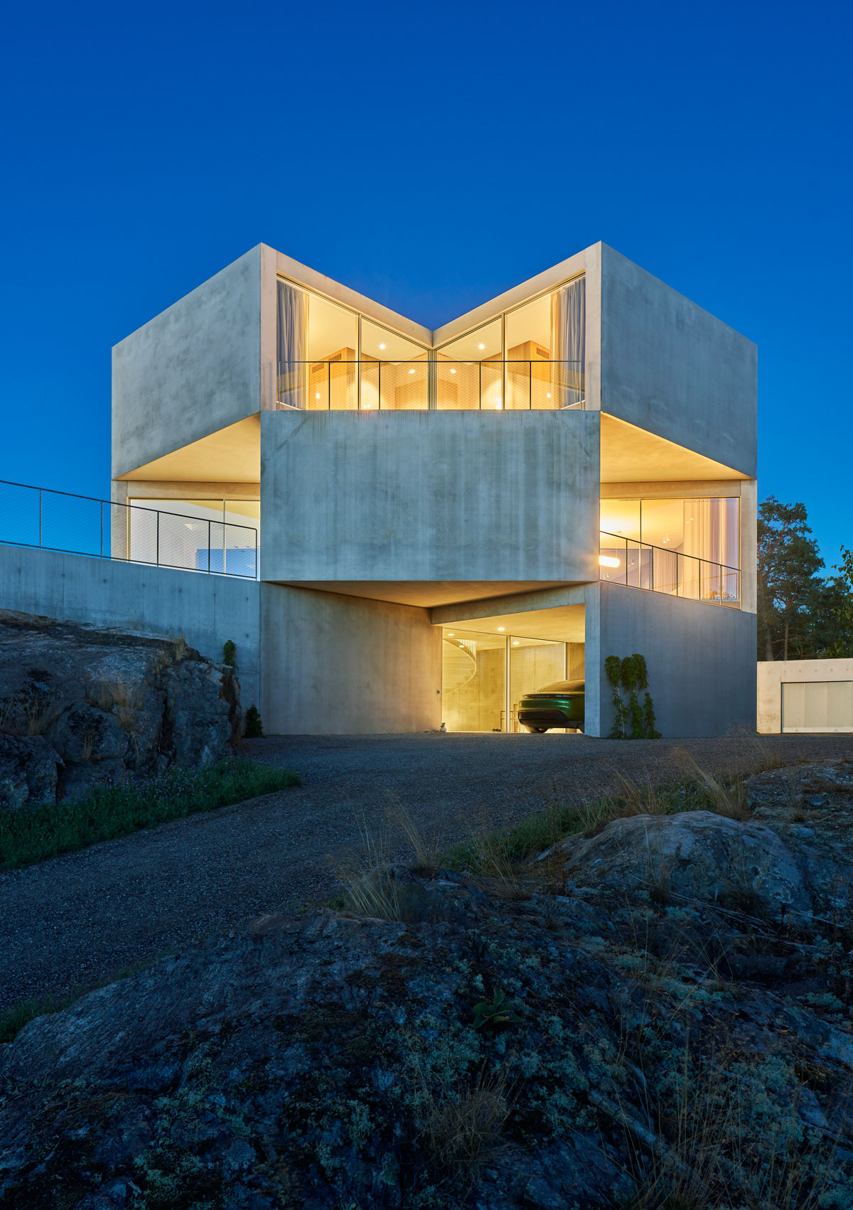 The house is lit with accent lighting during the night, giving off a dramatic effect.