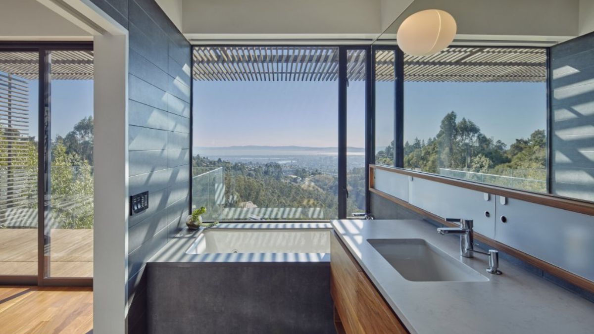 Displayed in the picture is a segment of the kitchen area, with emphasis on the single-basin sink and the panoramic view outside, visible through the surrounding glass windows.