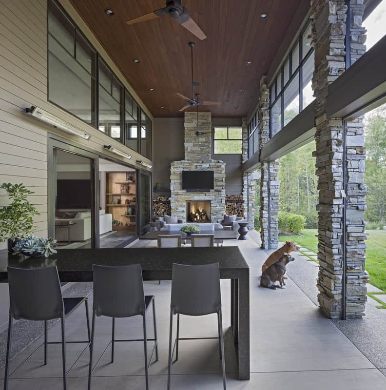 The outdoor living and dining are warmed by a large stone fireplace.