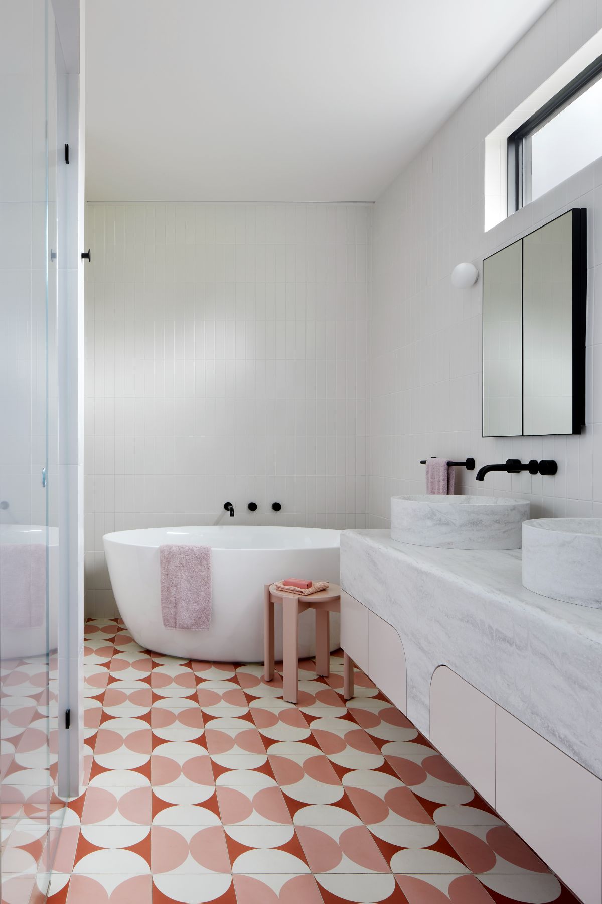 Art Deco inspired large ensuite bathroom with pink and cream Butterfly tile from Perini, featuring a top mounted, double sink from corian, Forme L'isola Freestanding Bath and walk in shower.