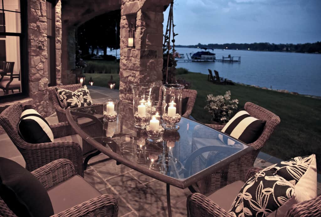 Outdoor dining with wicker armchairs and a glass-top table completes the covered porch.Outdoor dining with wicker armchairs and a glass-top table completes the covered porch.