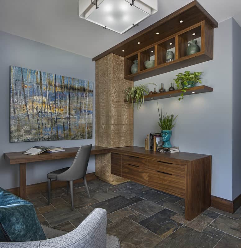 The home office has built-in desks and floating shelves filled with decorative vases.