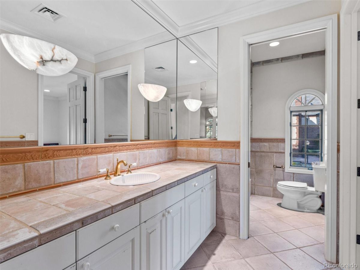 The bedroom's bathroom features a floating vanity with a tile countertop.